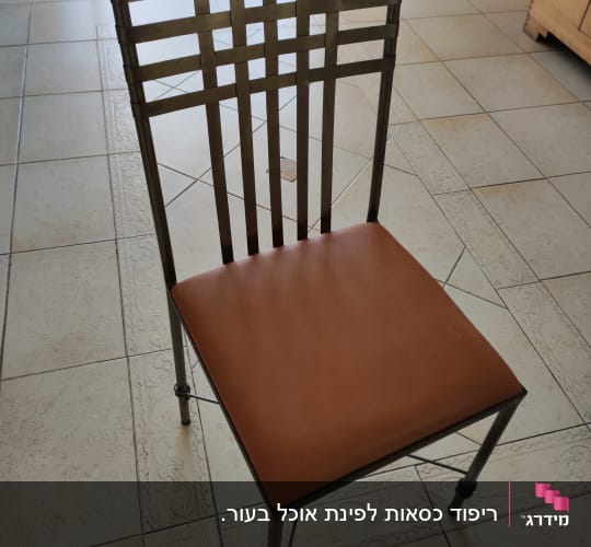 כיסא עם ריפוד עור חום על רצפה מרוצפת
